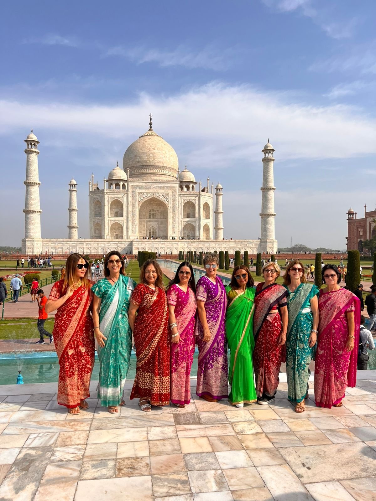 Women travellers wearing sarees at Taj Mahal — India cultural tour Sanoli India Tours